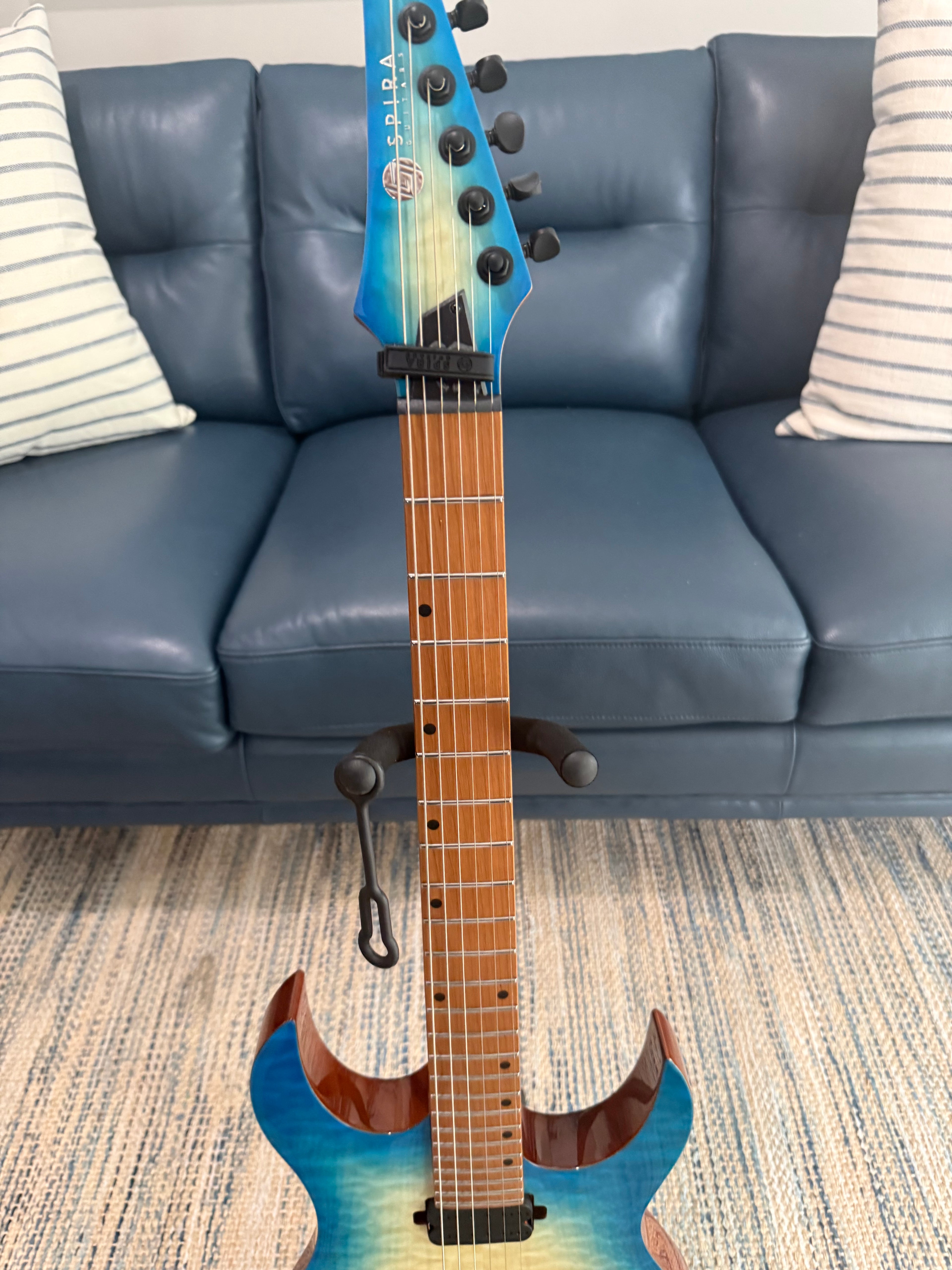 Spira S-500 QAB acoustic guitar with natural wood finish from Palm Harbor Music, showing the body and strings.