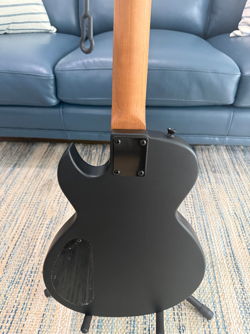 Palm Harbor Music Spira L-400 MBK guitar with black finish, showing the body, neck, and strings in a close-up view.