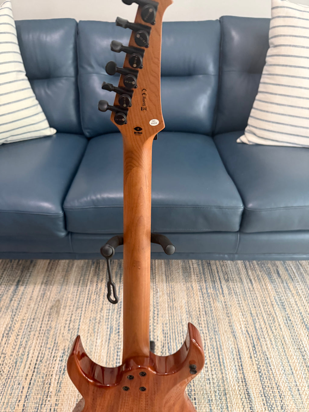 Palm Harbor Music Spira S-500 QAB bass guitar with a sleek black finish and modern design, shown on a stand.