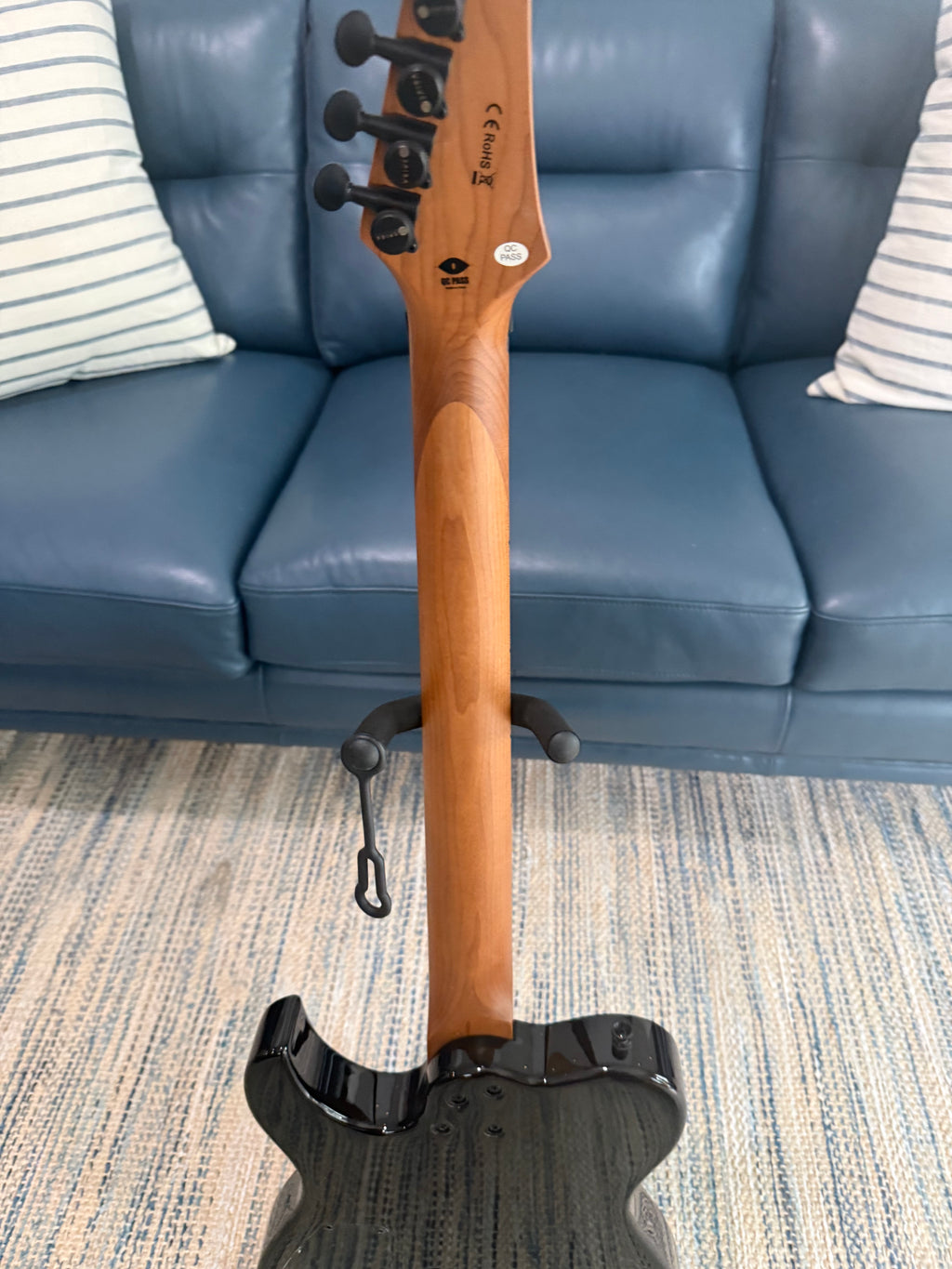 Palm Harbor Music Spira T-450 TDB guitar with a sleek wooden body and six strings, displayed on a stand against a neutral background.