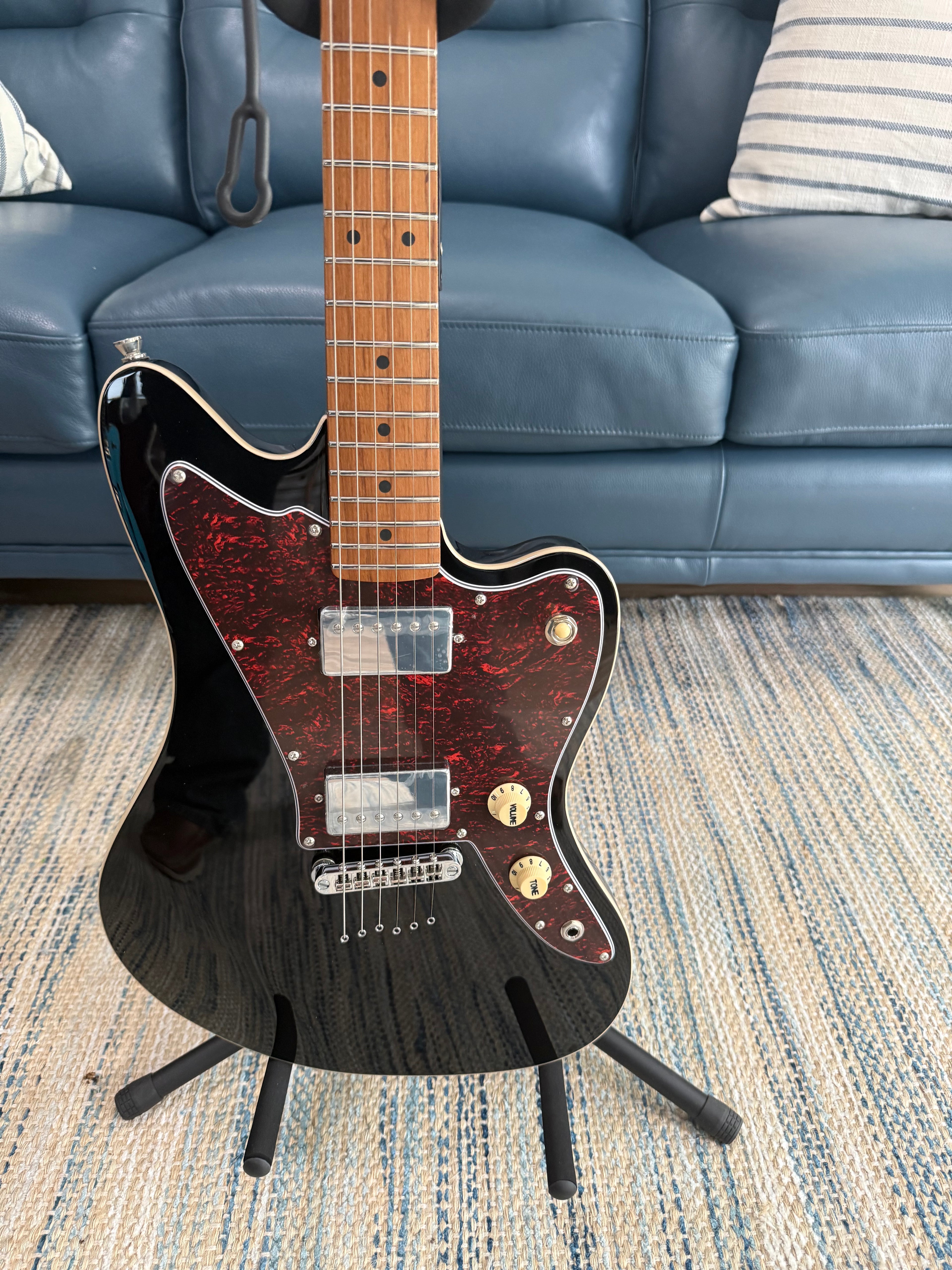 Palm Harbor Music JET JJ-350 BK electric guitar with black finish, featuring a solid body and six strings, close-up view of the instrument.