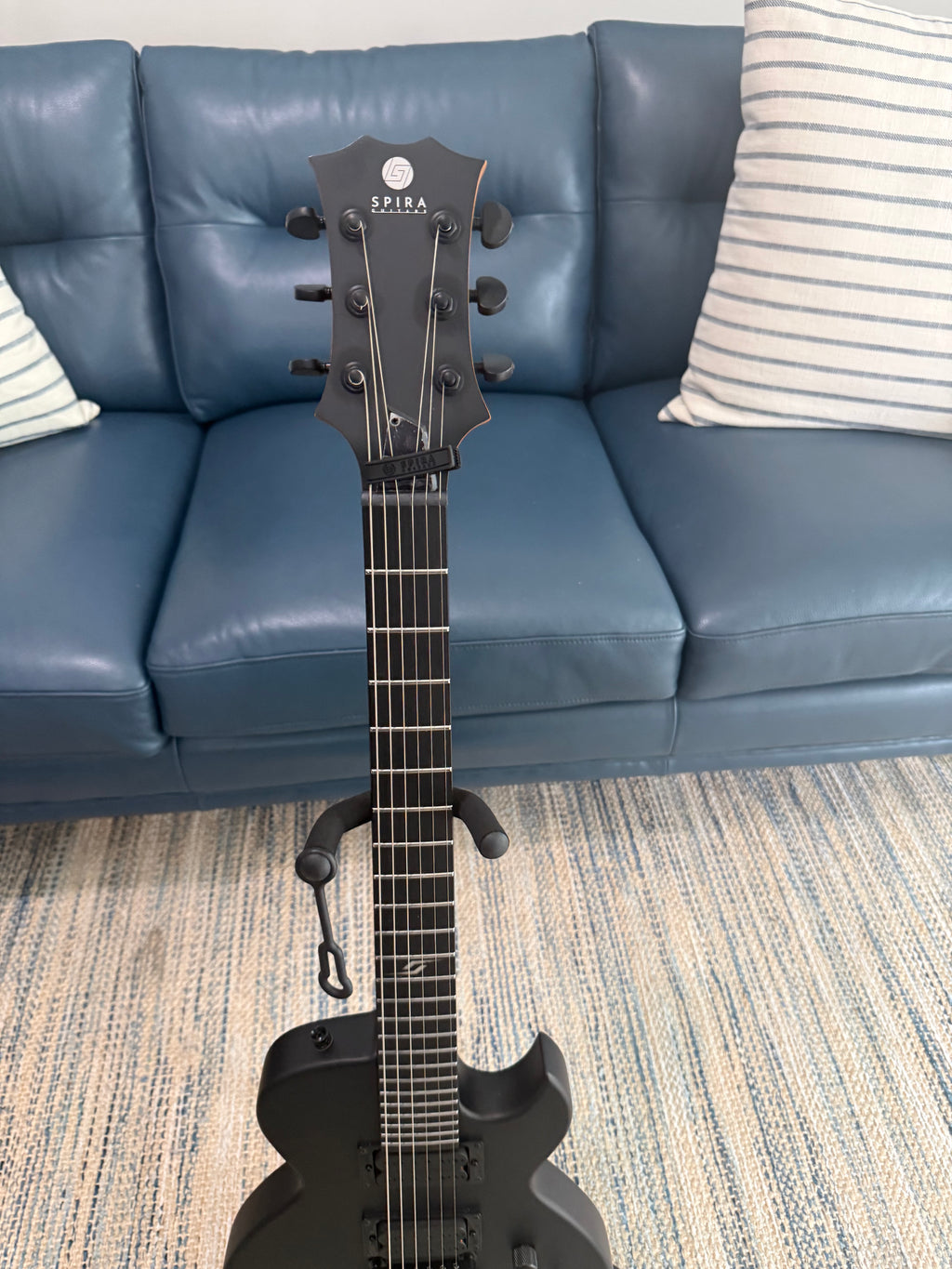 Palm Harbor Music Spira L-400 MBK bass guitar with black finish and sleek body design, shown in a close-up image.