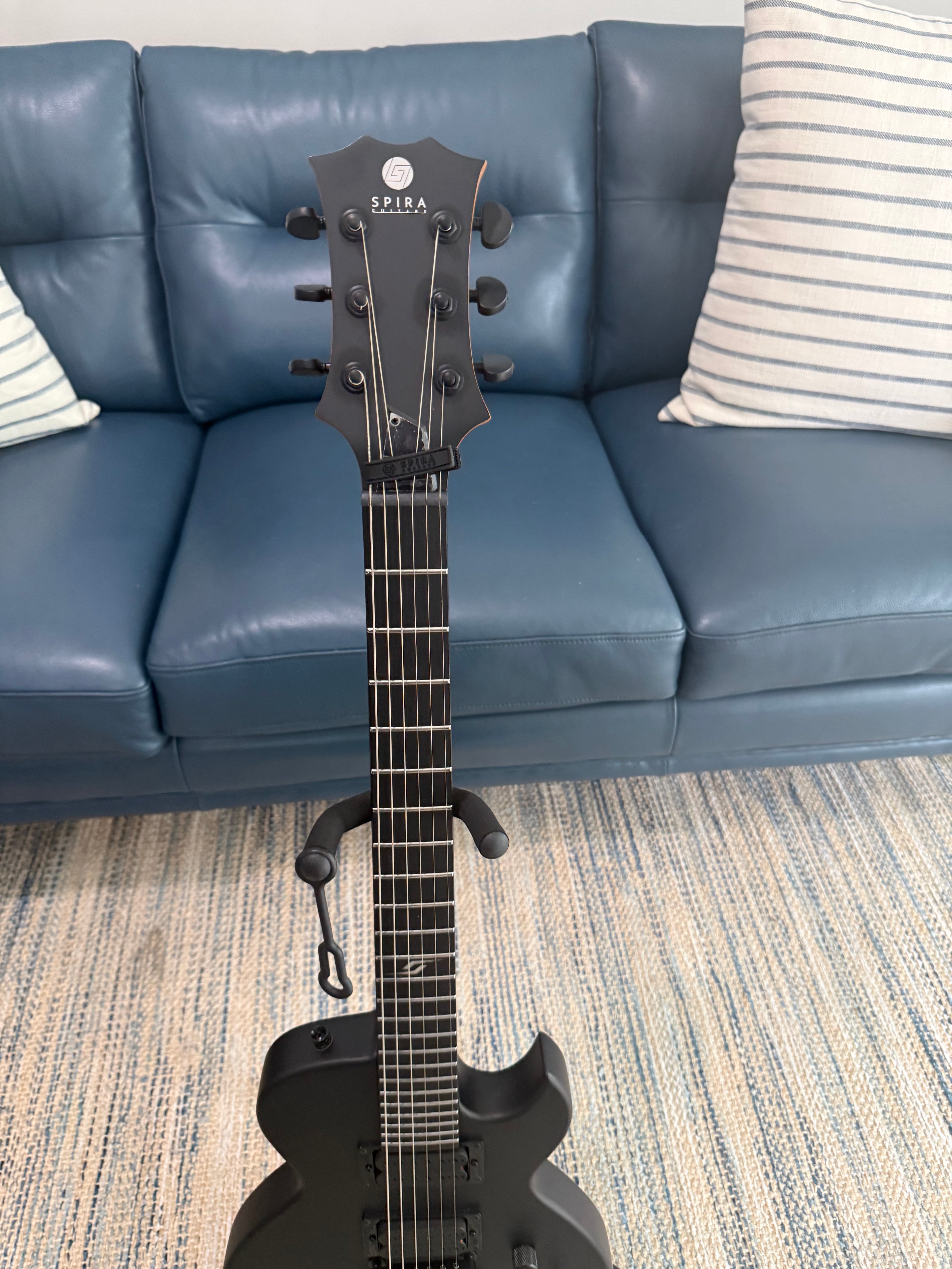 Palm Harbor Music Spira L-400 MBK bass guitar with black finish and sleek body design, shown in a close-up image.