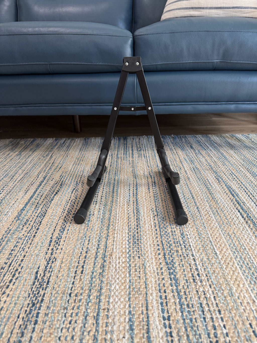 Folding A-frame guitar stand by Palm Harbor Music holding an acoustic guitar, compact and portable design for easy storage.