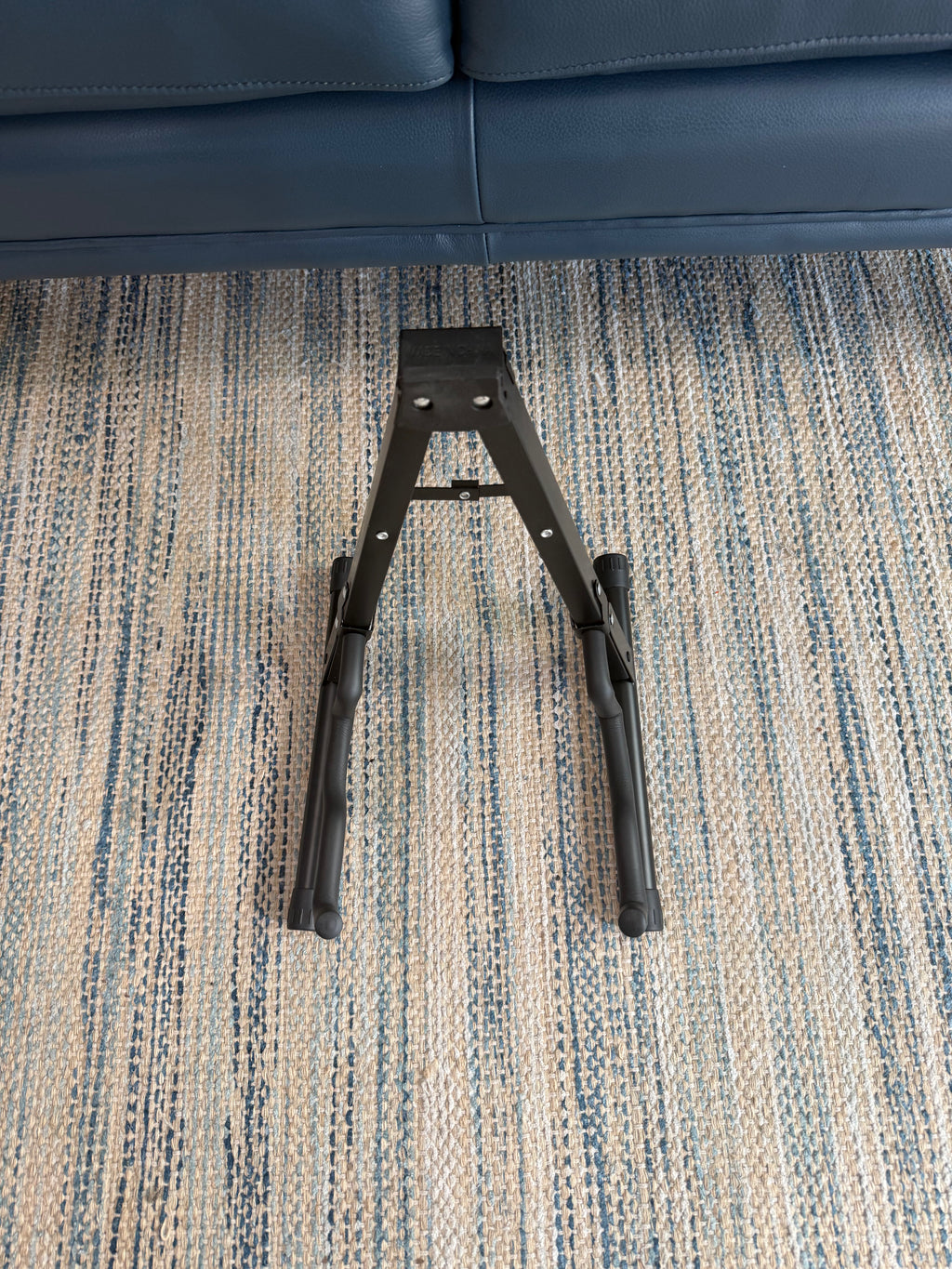 Folding A-frame guitar stand by Palm Harbor Music holding an acoustic guitar, portable and adjustable for easy storage.