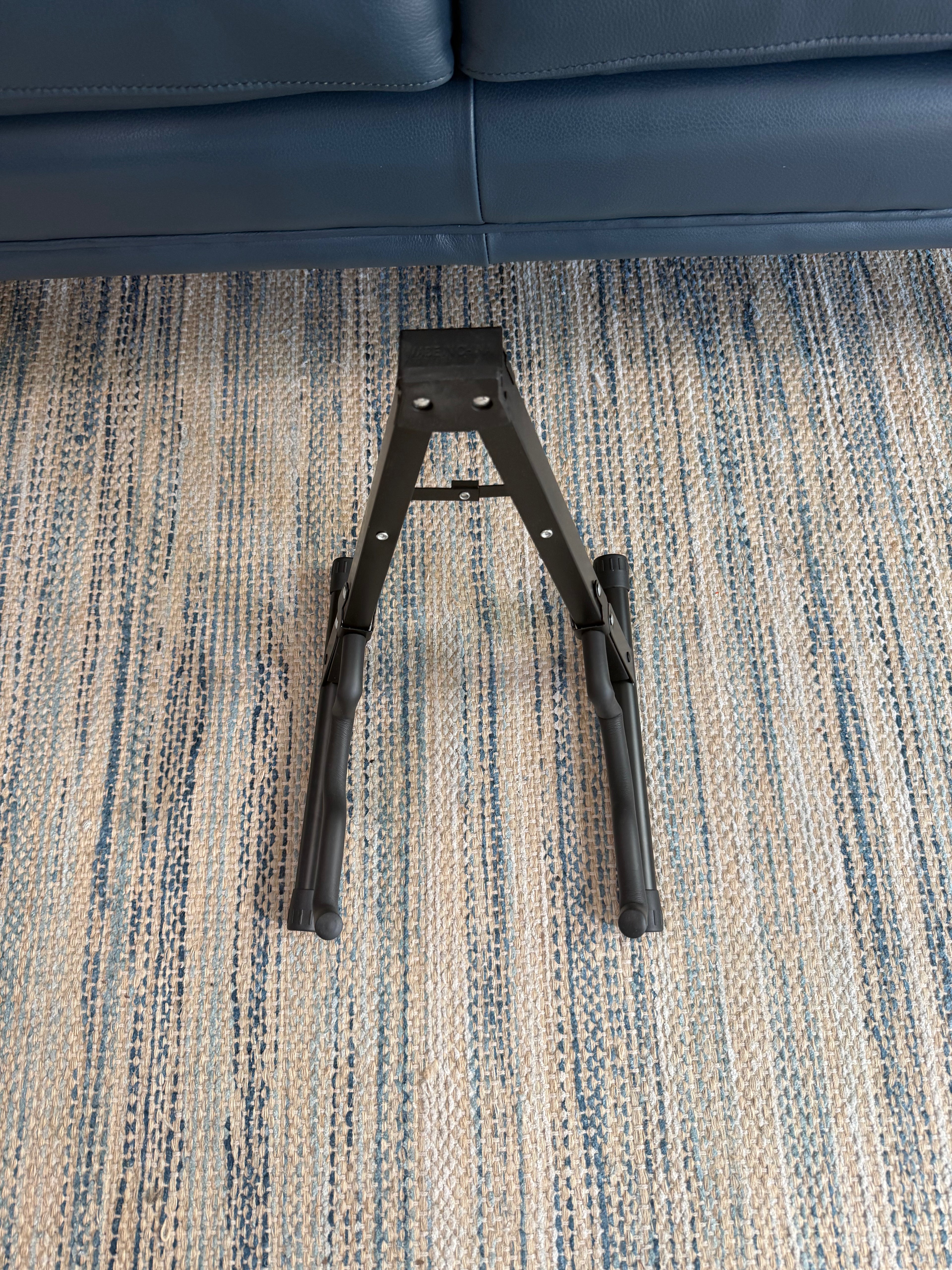 Folding A-frame guitar stand by Palm Harbor Music holding an acoustic guitar, portable and adjustable for easy storage.