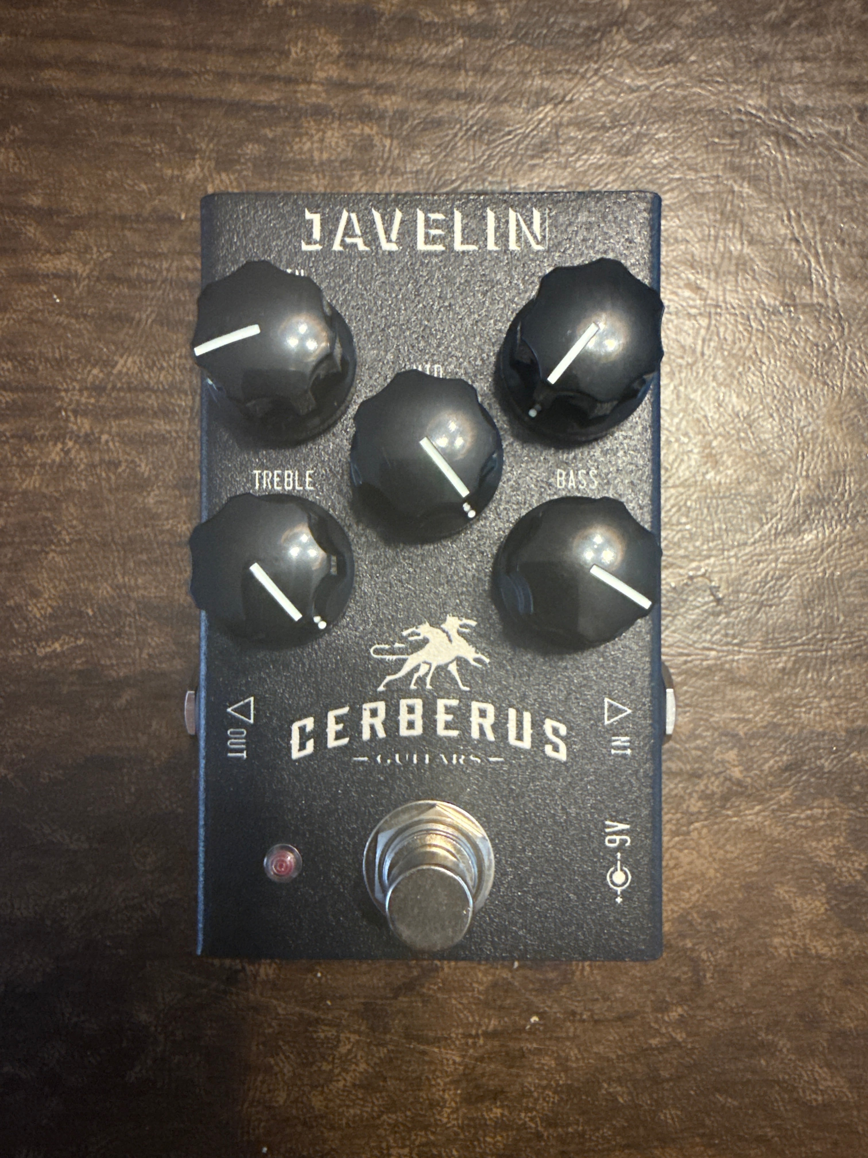 Guitar effects pedal with 'Javelin' and 'Cerberus' branding on a wooden surface