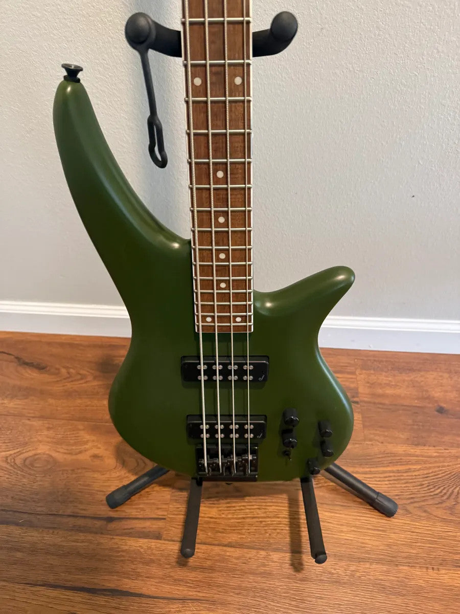 Used Jackson X Series Spectra SBX IV electric bass guitar in matte army drab finish with sleek design and four strings.