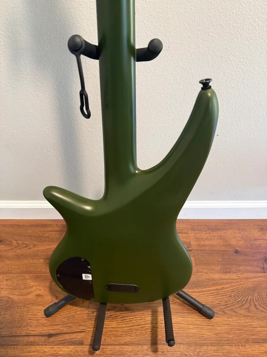 Used Jackson X Series Spectra SBX IV electric bass guitar in matte army drab finish with sleek design and four strings.