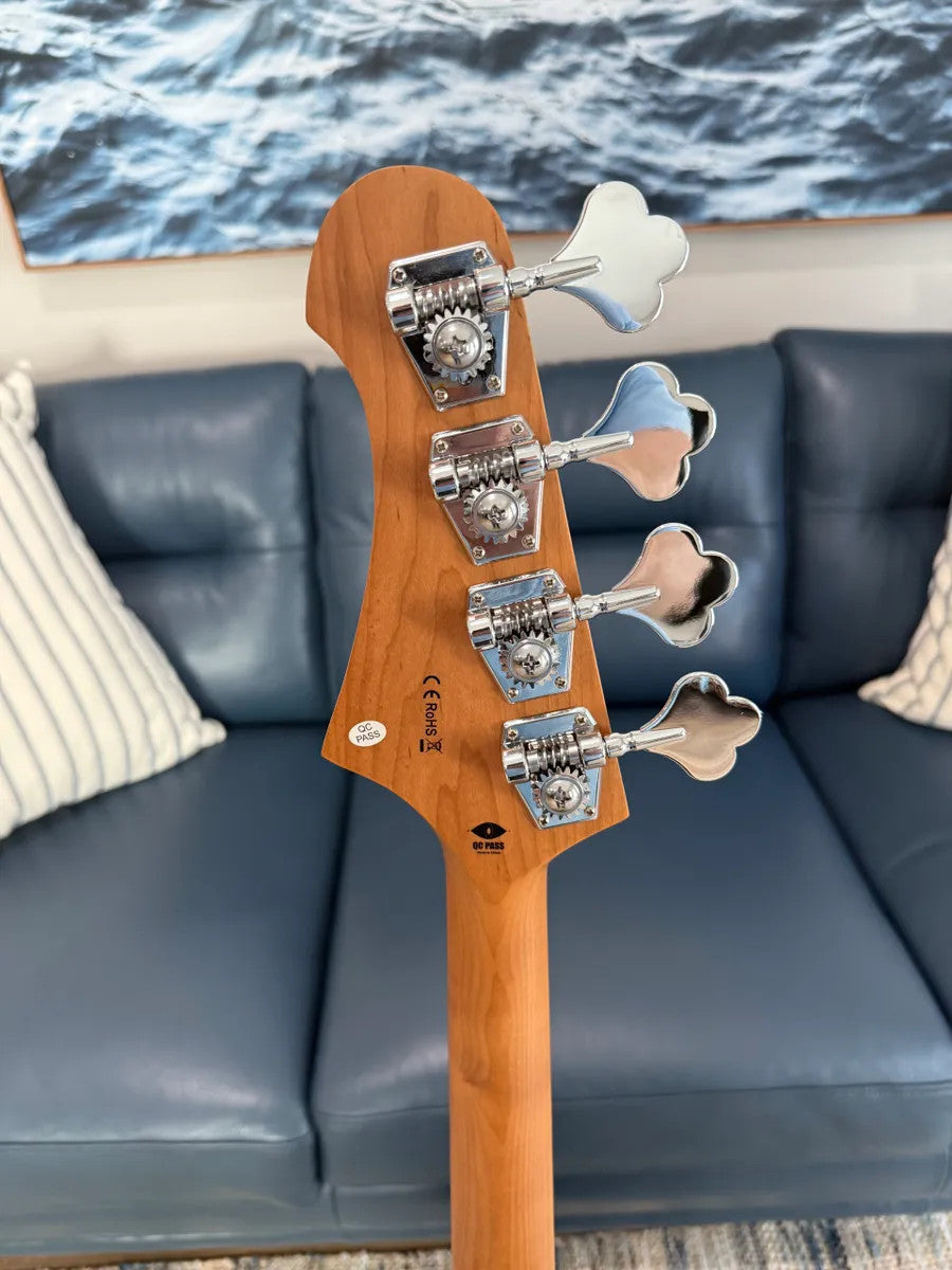 Jet Guitars JJB-300 GD R Bass featuring a sleek gold finish and classic body shape on a stand.