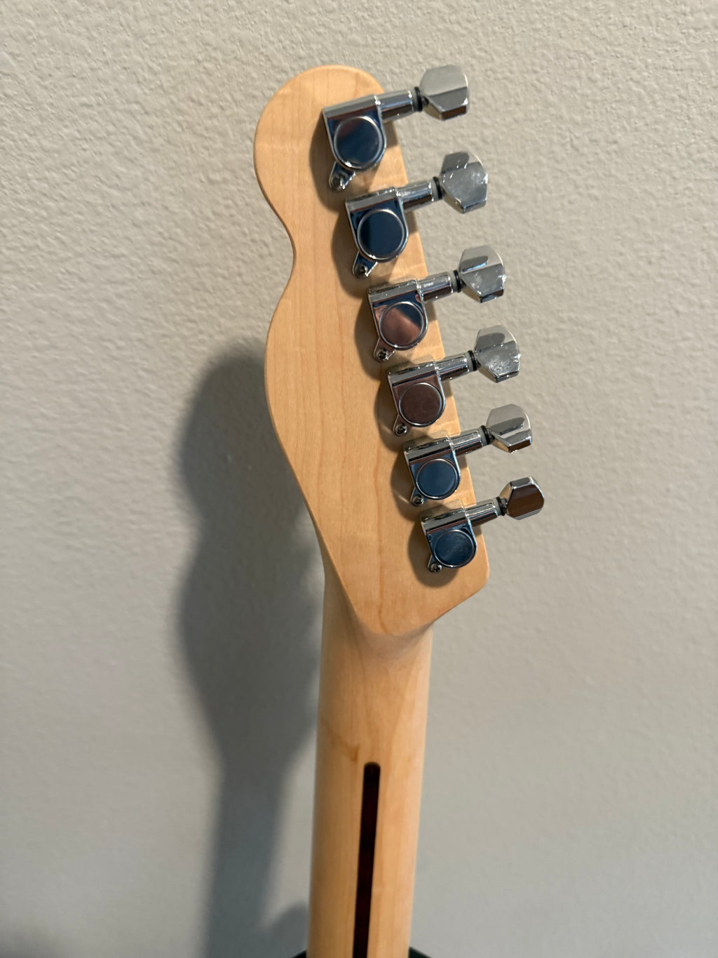 Custom Telecaster by Palm Harbor Music with a vibrant finish and distinctive body shape on a wooden backdrop.