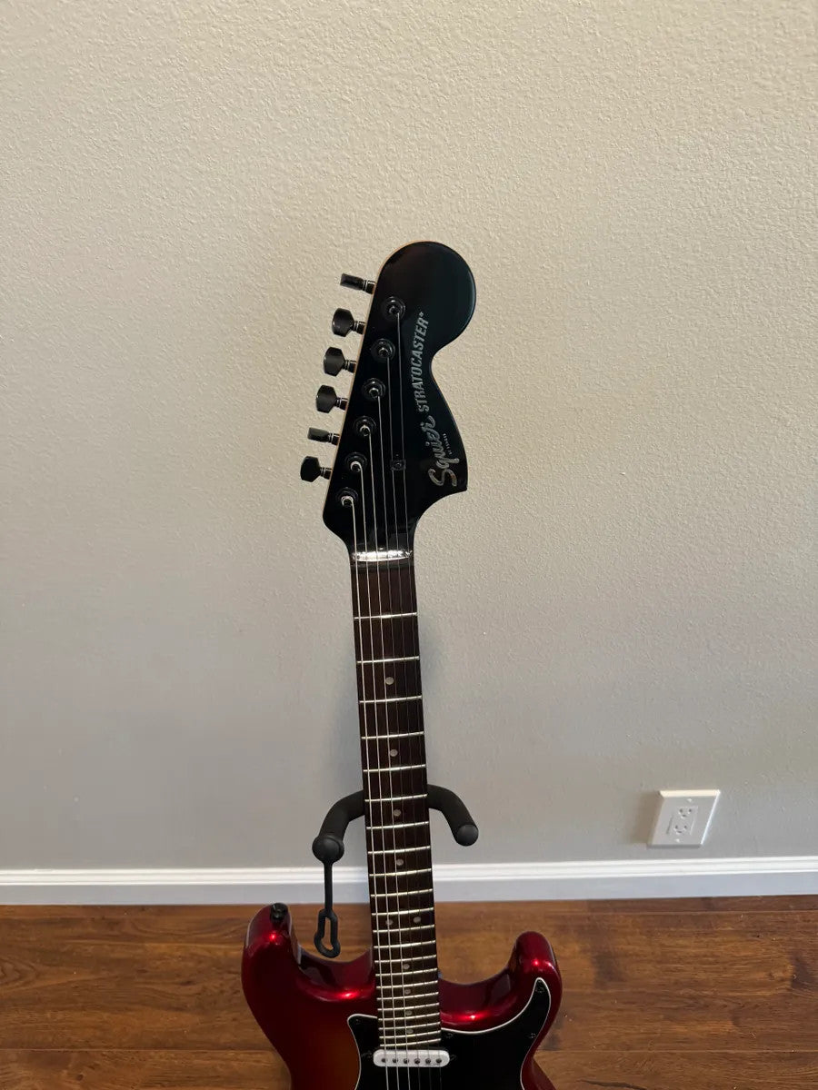 Used Squier Contemporary Stratocaster guitar in Sunset Metallic finish, showcasing its sleek body and vibrant color.