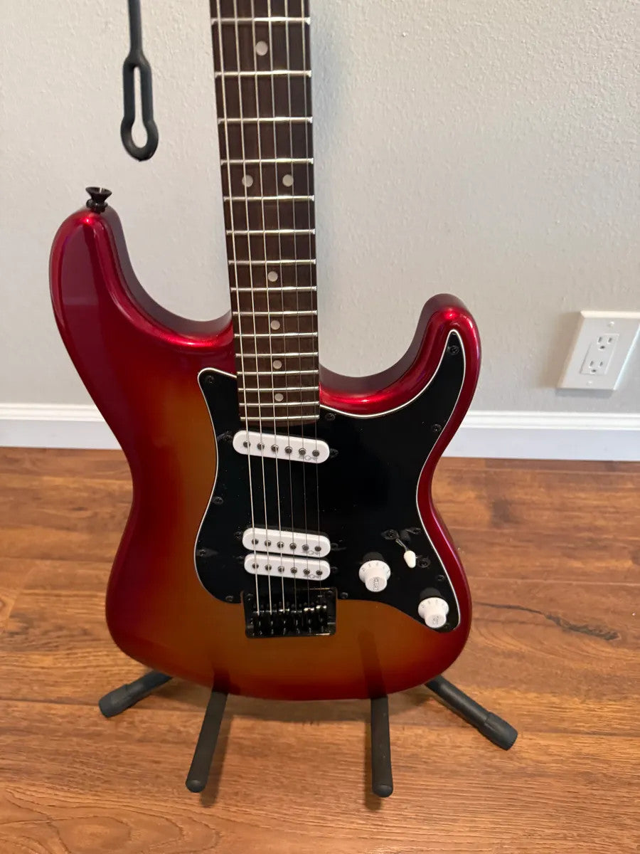 Used Squier Contemporary Stratocaster in Sunset Metallic finish, showcasing its sleek body and vibrant color.