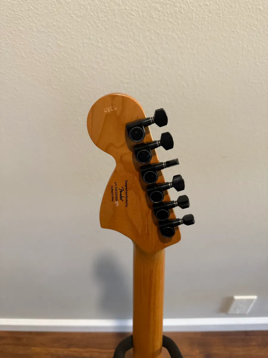 Used Squier Contemporary Stratocaster guitar in sunset metallic finish, showcasing its sleek design and vibrant color.