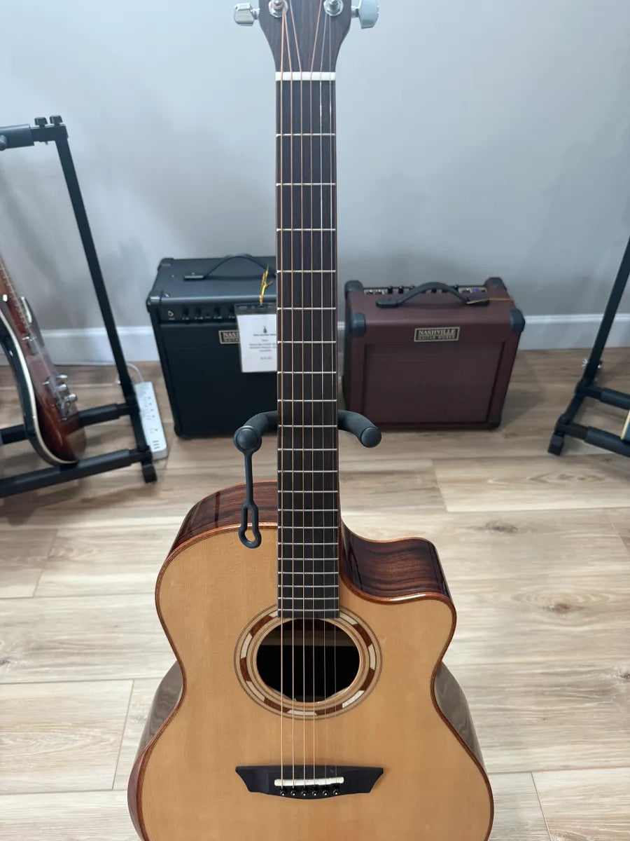 Used Washburn WCG20SCE acoustic electric guitar with a sleek body and natural wood finish, showing fretboard and strings.
